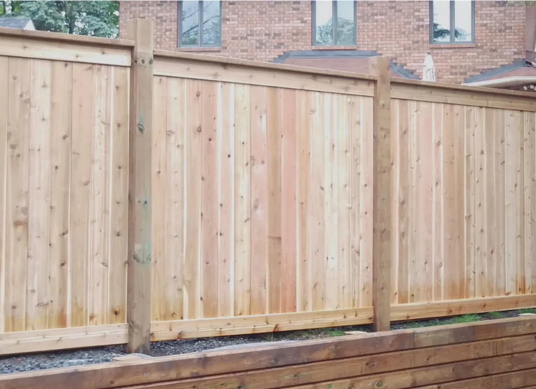 Weathered wood fence panels and posts showing the surfaces to check for aging and wear.