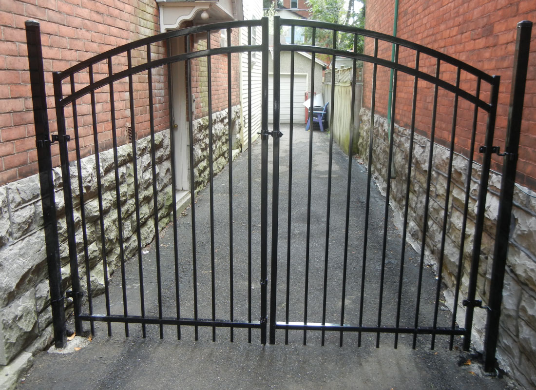 Ornamental Iron Estate Fence installed in Ottawa, Ontario by Fence Masters Ottawa — Black powder-coated iron panels with spear-top pickets and a matched swing gate