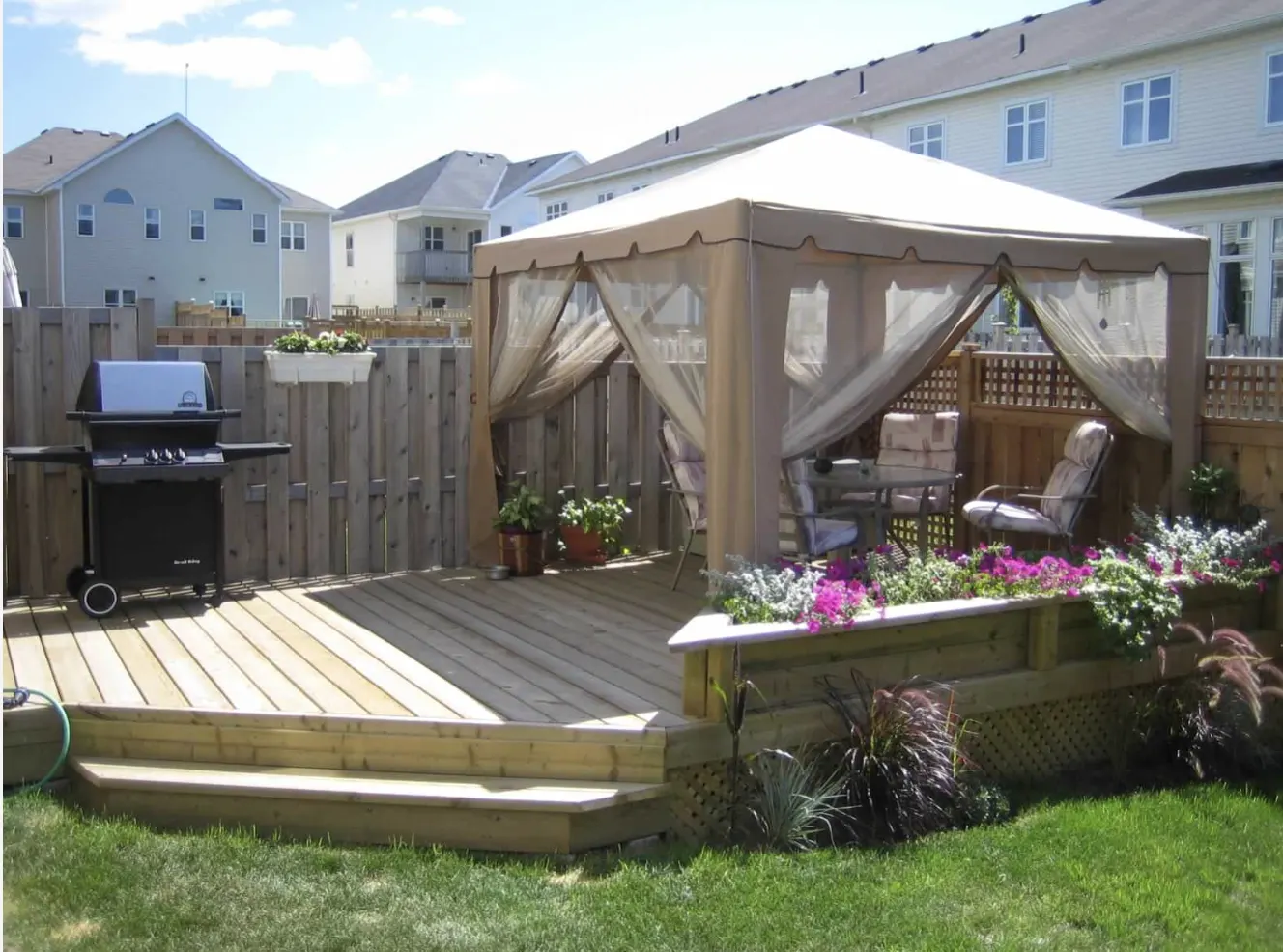 Ground-Level Deck & Gazebo installed in Barrhaven, Ontario by Fence Masters Ottawa — Pressure-treated deck with wide entry steps, planter box and a shaded gazebo lounge